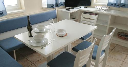 a white table with a bottle of wine and a wine glass at Claire's Apartment in Wagrain