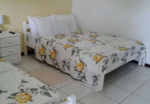 1 dormitorio con 1 cama con colcha de flores en Axé Brasil, en Búzios