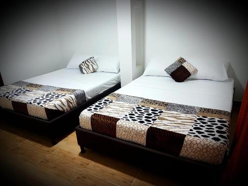 - deux lits assis l'un à côté de l'autre dans une pièce dans l'établissement Finca Hotel La Linda, à Quimbaya