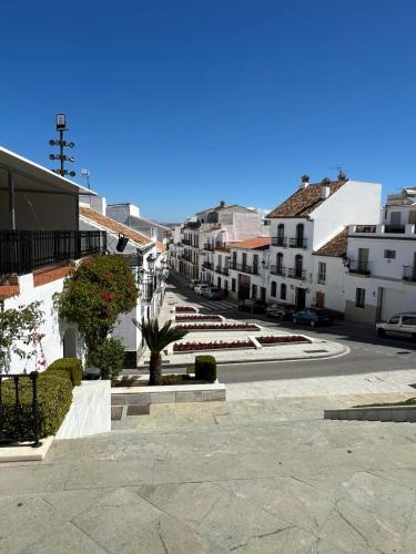 una calle de la ciudad con edificios blancos y un cielo azul en San Antonio, en Alhaurín el Grande