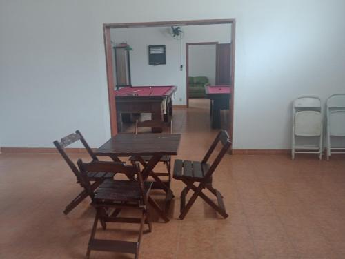 uma mesa e cadeiras numa sala com mesas de bilhar em Espaço temporada Gardenias Guaratinguetá Proximo Basilica de Aparecida em Guaratinguetá