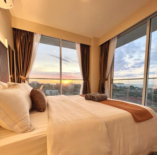 a bedroom with a large bed with a large window at AruSuites Tanjung Aru Kota Kinabalu By Wellstay in Kota Kinabalu