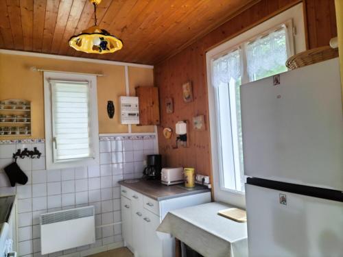 een kleine keuken met een koelkast en een raam bij Maison avec jardin de 600 m2 au cœur des cévennes in Sénéchas