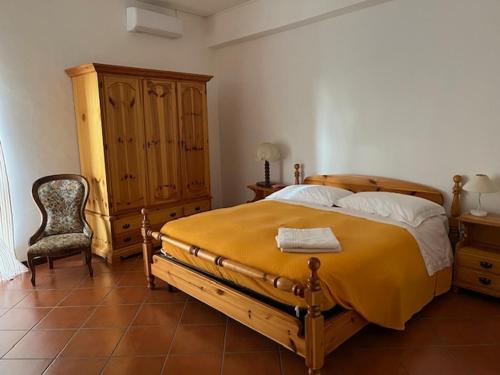 1 dormitorio con 1 cama grande y 1 silla en POGGIO&TRAMONTO, en Otricoli