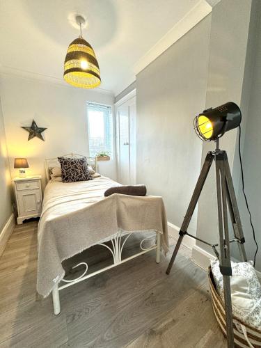 a bedroom with a bed and a lamp and a tripod at Chester's - Central Chester Stays - City Walls - Private Garden Overlooking River Dee in Chester