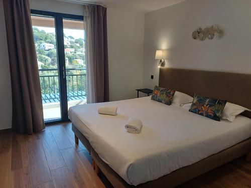 a bedroom with a large bed with a large window at Hôtel Casa Mea in Bastia