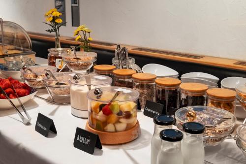 a table with jars of food and a bowl of fruit at Hotel Sonnenstube Hagnau in Hagnau