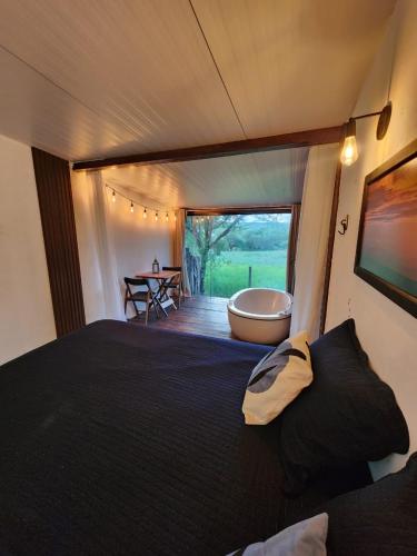 a bedroom with a large bed and a bath tub at Suítes Domo do Matto in Garanhuns
