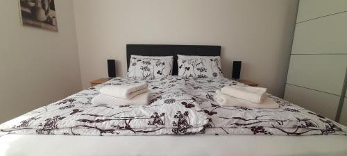 Cama blanca con edredón y almohadas blancos y negros en Appartamento No. 1, en Opatija
