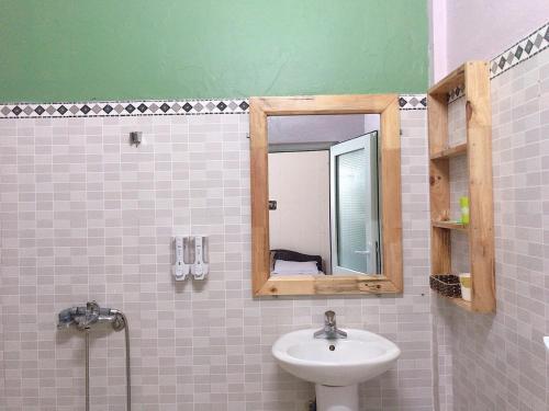 Hoa Mai Hotel في دونغ هوي: حمام مع حوض ومرآة