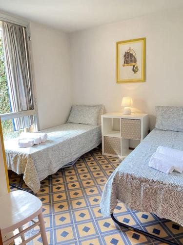 a room with two beds and a table and a window at Villetta Cortona in Marina di Pietrasanta