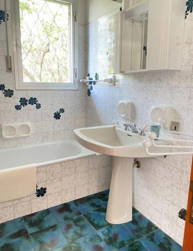 a white bathroom with a sink and a bath tub at Villetta Cortona in Marina di Pietrasanta