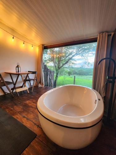 a large white tub in a room with a table at Suítes Domo do Matto in Garanhuns