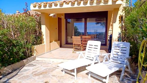 two white chairs on the patio of a house at Dimora Simius in Villasimius