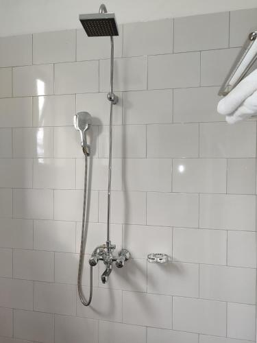a shower with a shower head in a bathroom at Garden Courts Hotel Masaka in Masaka