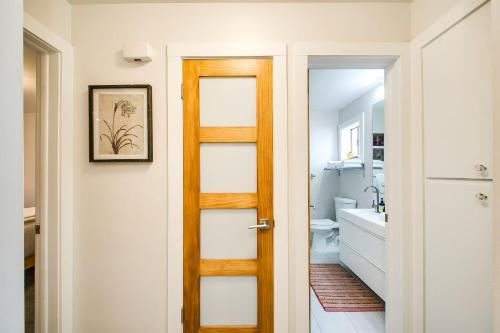 ein Badezimmer mit einer Holztür und einem Waschbecken in der Unterkunft Ninth Street Retreat in Boise