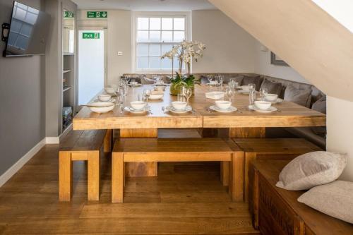 a dining room table with plates and bowls on it at Luxurious Family Townhouse 50m from the Beach in Brighton & Hove