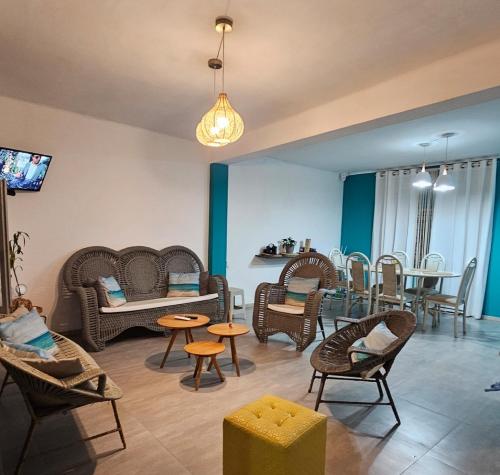 een woonkamer met rieten stoelen en een eetkamer bij Casa de Playa Tortugas Casma, Habitación 4 a 6 personas con 1 baño in Tortuga