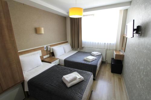 a hotel room with two beds and a window at Metrohill Hotel in Istanbul