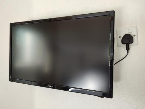 a flat screen tv hanging on a wall at Garden Courts Hotel Masaka in Masaka