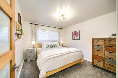 ein Schlafzimmer mit einem Bett, einer Kommode und einem Fenster in der Unterkunft Ninth Street Retreat in Boise