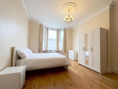ein Schlafzimmer mit einem Bett und einem großen Fenster in der Unterkunft Spot Homes Guest House in London