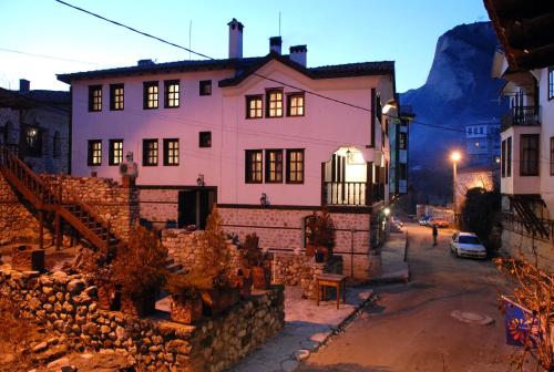 a house with a stone wall in front of a street at Hotel Bolyarka in Melnik