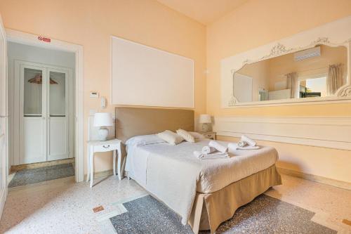 Schlafzimmer mit einem Bett und einem Wandspiegel in der Unterkunft Dimora Le Tre Muse Guesthouse in Lecce