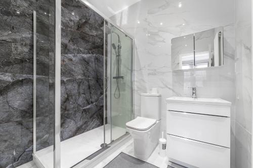 een witte badkamer met een douche en een toilet bij Spot Homes Guest House in Londen