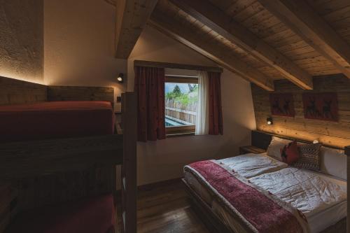 馬東納迪坎皮利奧的住宿－Rifugio Lago Malghette，一间卧室设有两张床和窗户。