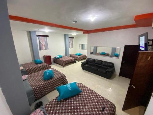 sala de estar con 3 camas y sofá en hotel roger Inn mazatlan, en Mazatlán
