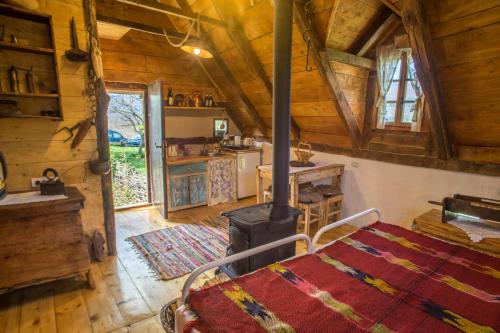 a bedroom with a bed and a stove in a cabin at Djurdjevina Family Farm in Kolašin