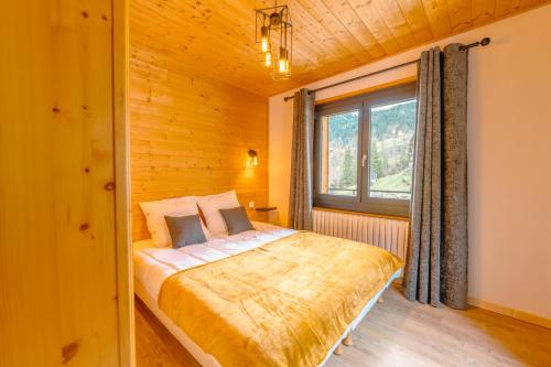 1 dormitorio con 1 cama en una habitación con ventana en Etoile des Vents en Morzine