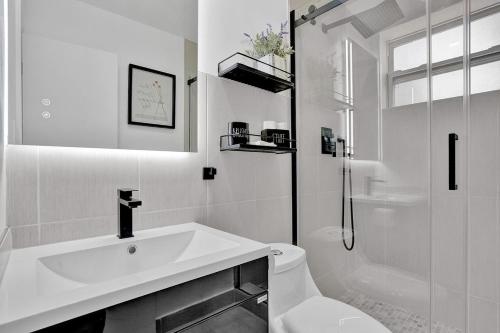 a white bathroom with a sink and a shower at Hallandale Beach Family Vacation Home Backyard in Hallandale Beach