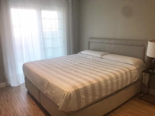 ein weißes Bett in einem Schlafzimmer mit zwei Fenstern in der Unterkunft Apartamento Familiar in Cambrils