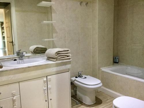 ein Badezimmer mit einem Waschbecken, einem WC und einer Badewanne in der Unterkunft Apartamento Familiar in Cambrils
