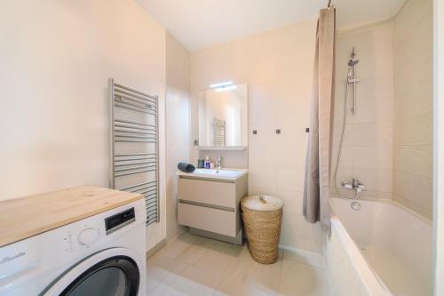 ein Badezimmer mit einem Waschbecken und einer Waschmaschine in der Unterkunft Le Rooftop de la Peyrière - Parking - Climatisation - 10 min de Montpellier in Saint-Jean-de-Védas