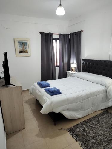 1 dormitorio con 2 camas y TV de pantalla plana en Dpto Nuevocentro Shopping en Córdoba