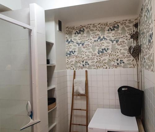 baño con aseo y pared de azulejos en Chez Stella, en Audierne