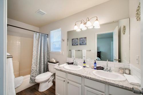 een badkamer met 2 wastafels, een toilet en een spiegel bij True Blue Family Home in Meridian