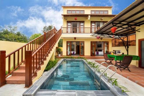 a house with a swimming pool in front of a house at Lama Beach Villa in An Bang