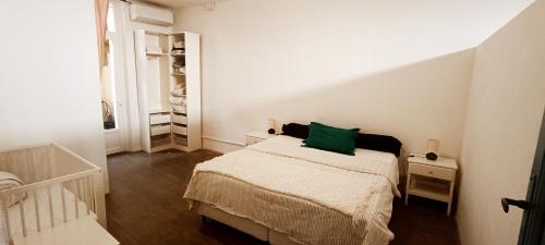 - une chambre dotée d'un lit avec un oreiller vert dans l'établissement Maison Provençale, à La Seyne-sur-Mer