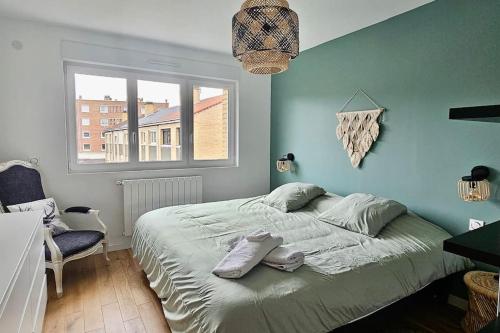 a bedroom with a bed and a blue wall at Maison proche du vieux Lille et de la citadelle avec place parking in Lambersart