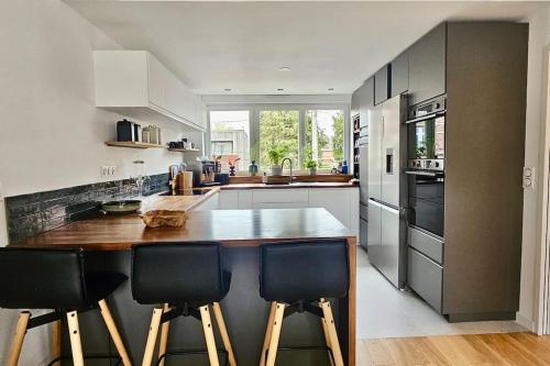 une cuisine avec un grand îlot en bois dans l'établissement Maison proche du vieux Lille et de la citadelle avec place parking, à Lambersart