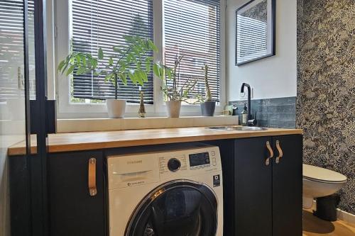 a washing machine in a bathroom with a sink at Maison proche du vieux Lille et de la citadelle avec place parking in Lambersart