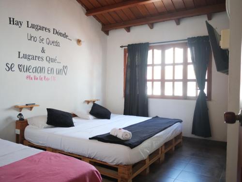two beds in a room with a sign on the wall at Habitacion en La Vie en Rose in Cartagena de Indias