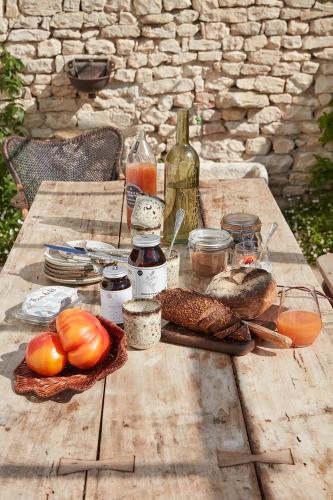 a wooden picnic table with bread and bottles of wine at Maisons 322 - Maison La Lumineuse in Le Bois-Plage-en-Ré