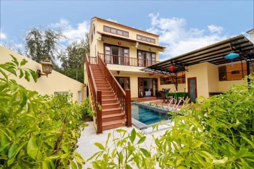 a house with a swimming pool in front of a house at Lama Beach Villa in An Bang