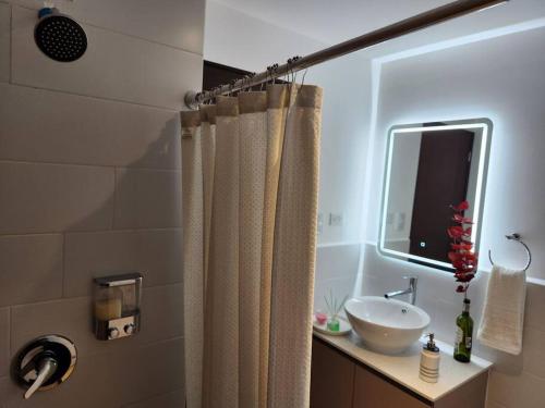 a bathroom with a shower curtain and a sink at La Floresta - Mejor opción relación calidad precio in Quetzaltenango