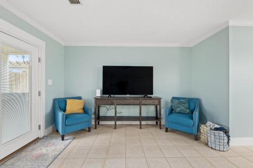 a living room with two blue chairs and a television at 2 BR Home in St Andrews, Close to Everything in Panama City